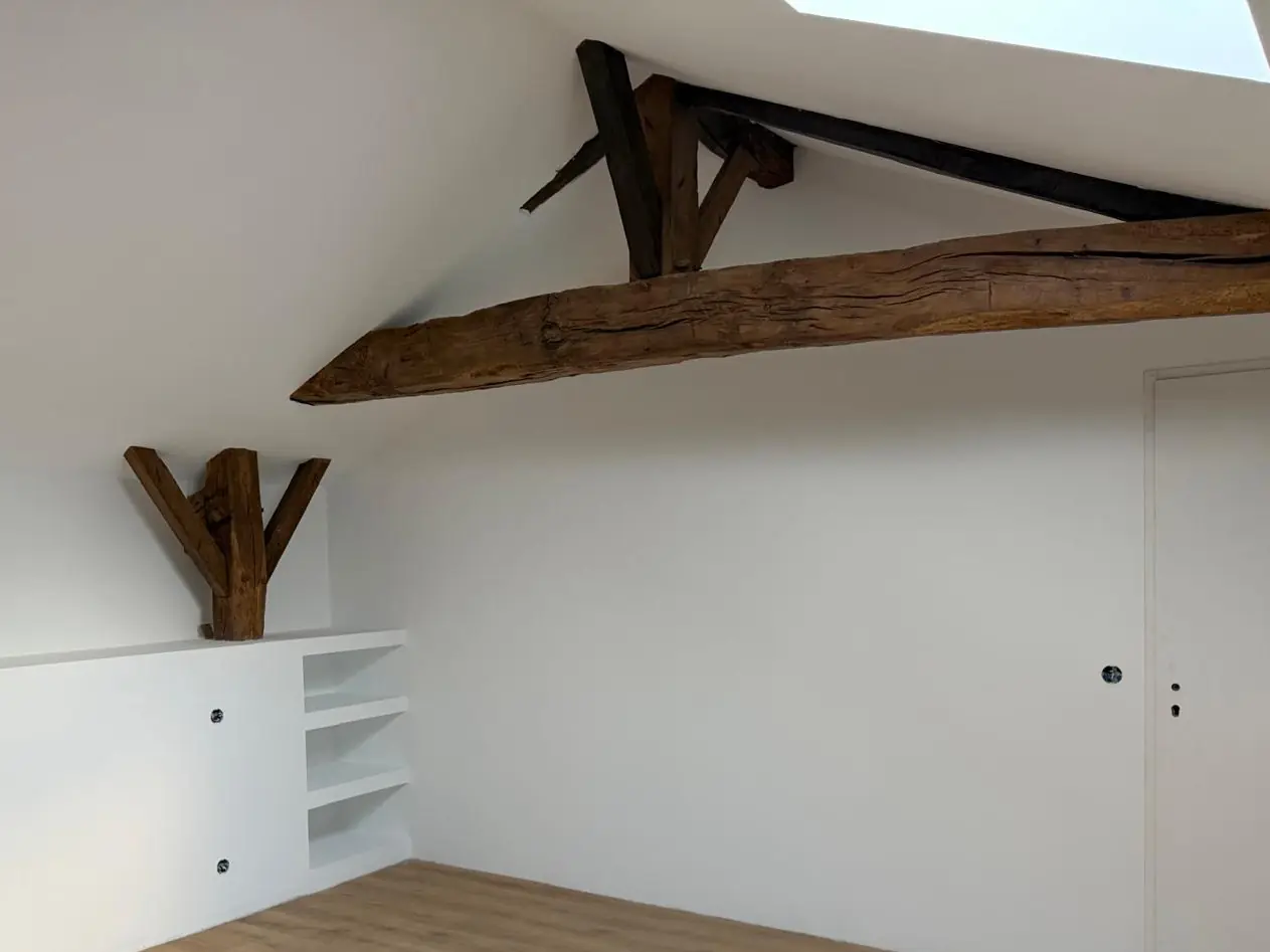 Après : la même pièce terminée, meuble bas et étagères blancs, poutre ancienne, porte, parquet