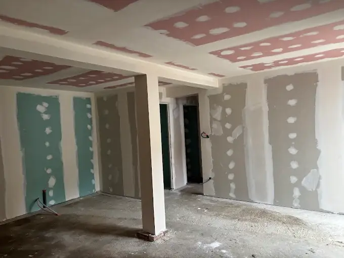 Pièce en cours de plâtrerie : plafond en plaques aux bandes enduites, cloisons avec plaques vertes hydrofuges