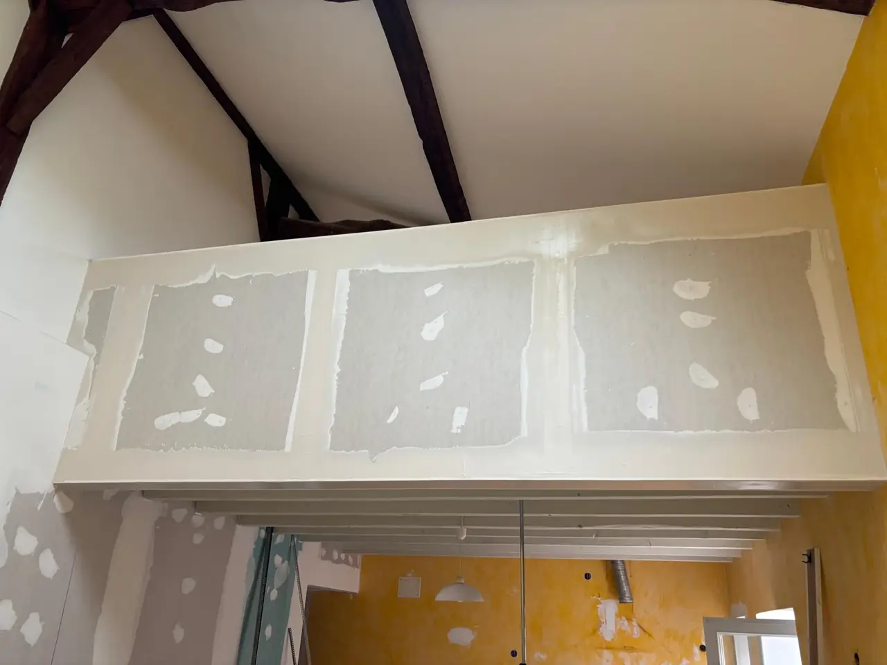 Garde-corps de mezzanine habillé en plaques de plâtre, bandes faites, vu d’en dessous